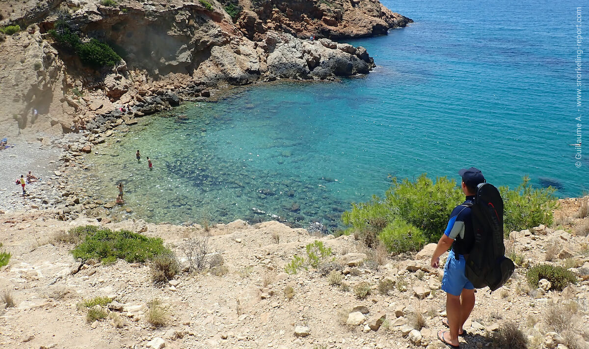 Snorkeler overlooking a rocky bay with translucent waters